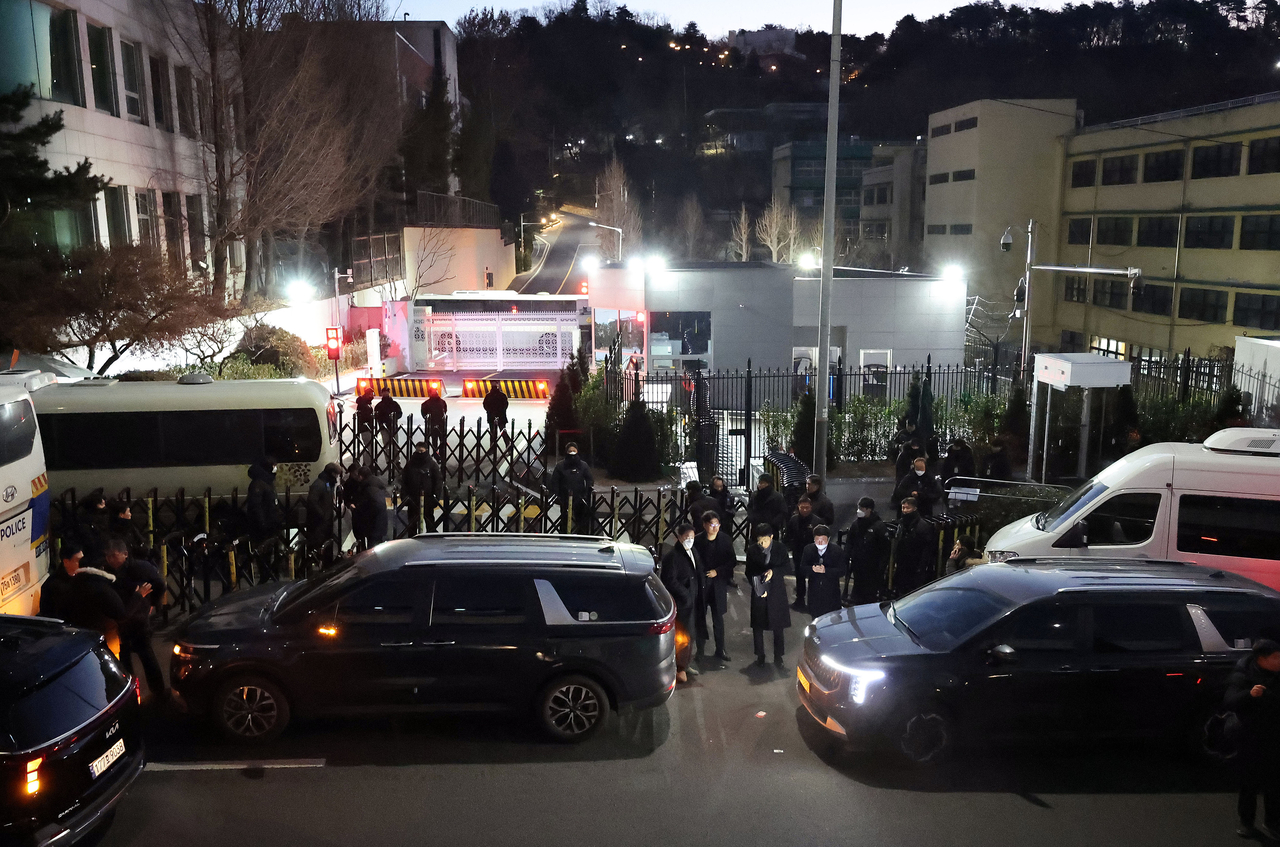 Investigators from the Corruption Investigation Office for High-ranking Officials are on standby outside President Yoon Suk Yeol's official residence in Seoul on Friday. (Yonhap)