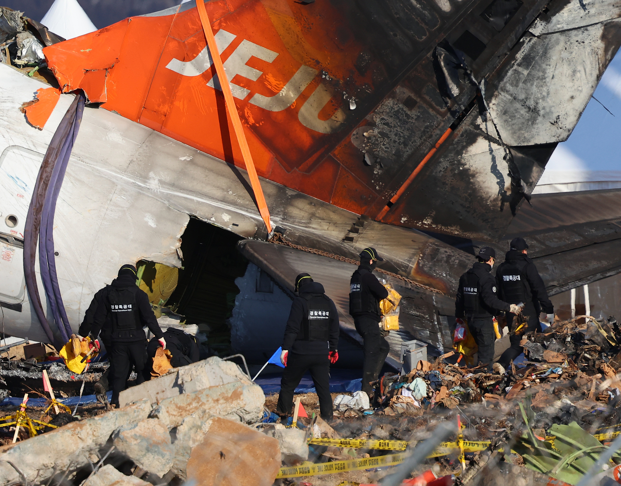 제주항공 여객기 참사 7일째인 4일 오후 무안국제공항 사고 현장에서 마무리 수색 작업을 하던 경찰특공대원들이 구명 조끼를 들고 현장을 나서고 있다. <연합뉴스>