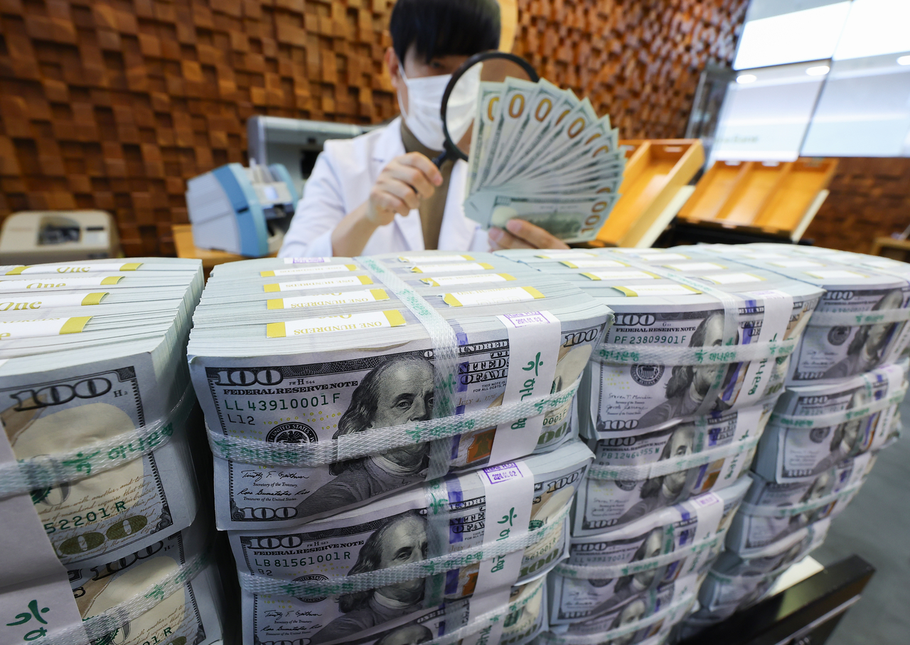 A banker checks dollars at Hana Bank's Counterfeit Notes Response Center in Seoul, in this file photo taken Dec. 19, 2024. (Yonhap)