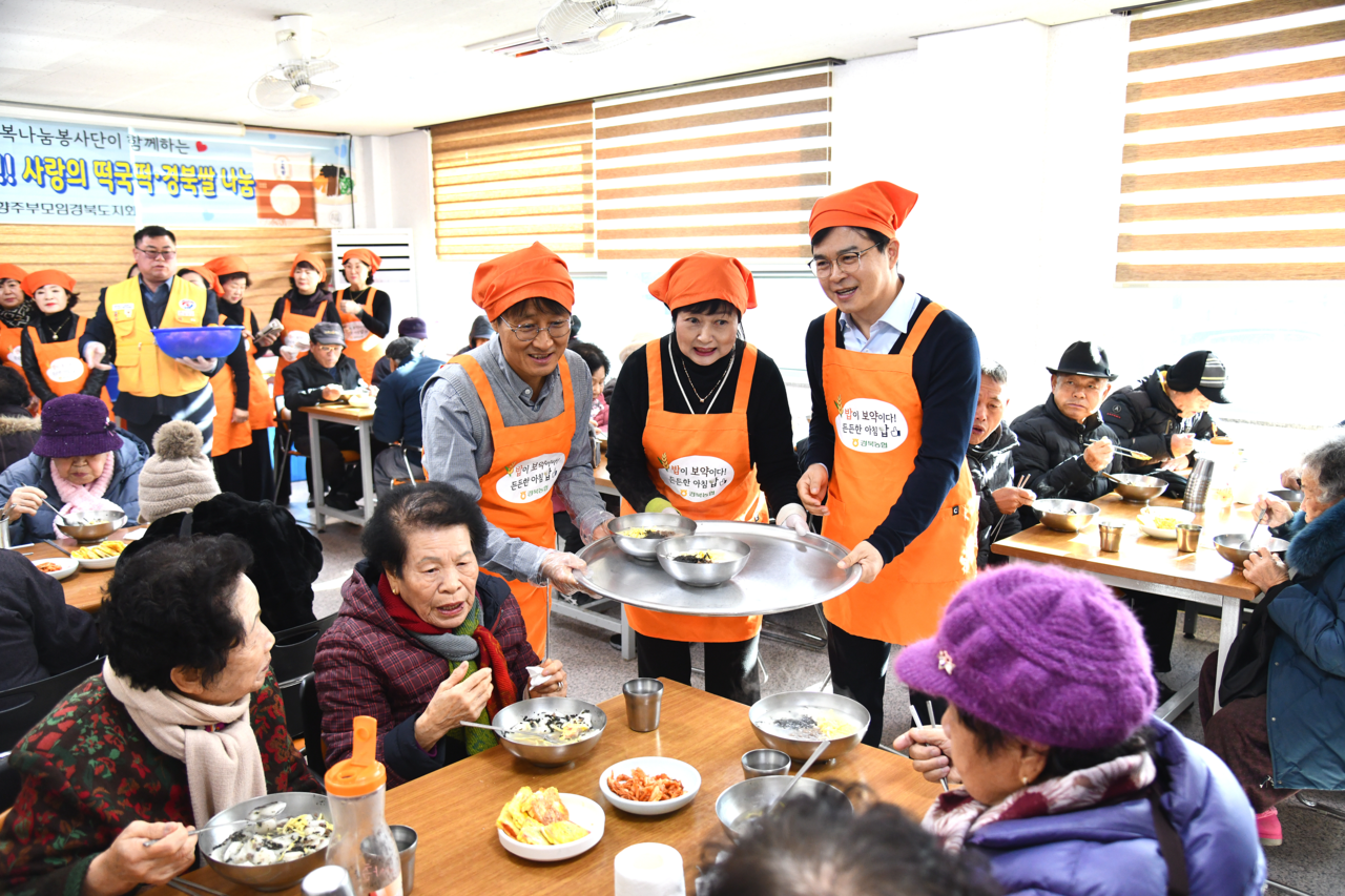 최진수(오른쪽)경북농협 본부장이 안동 나눔터를 찾아 봉사자들과 함께 우리쌀로 만든 떡국떡을 배식을 돕고 있다(경북 농협제공)