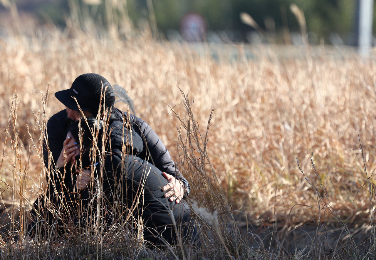 Family members of the victims of the Jeju Air plane crash cry near the crash site at Muan International Airport in South Jeolla Province on Monday, a day after the deadly incident claimed 179 lives. (Yonhap)