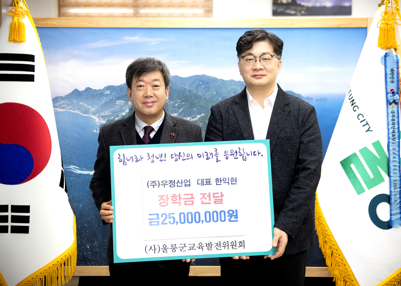 한익현(사진오른쪽) 우정산업대표가 남한권 울릉군수에게 장학기금2500만원을  전달하고 있다(울릉군 제공)