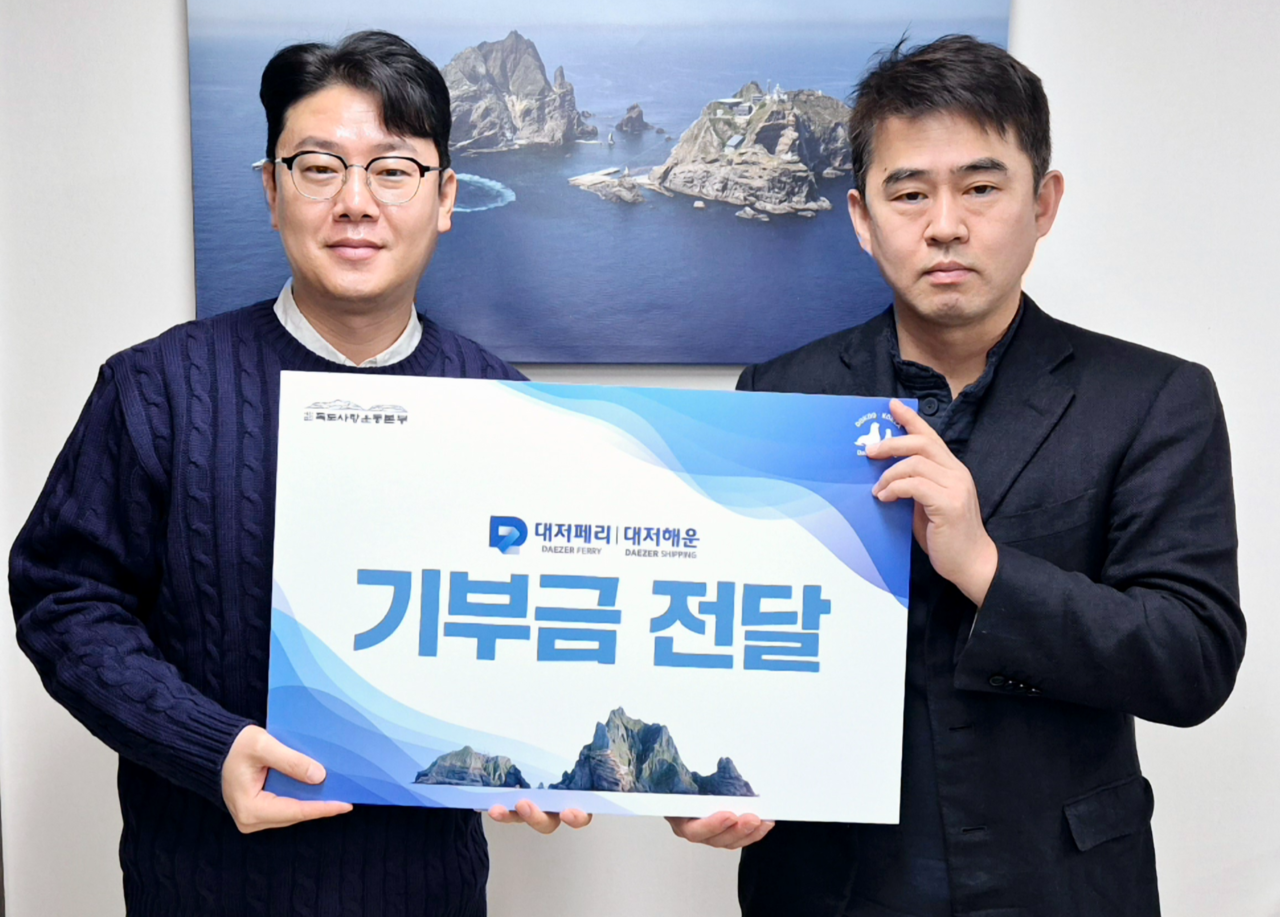 여객선사 김창준(오른쪽) 이사가 독도 사랑운동본부 사무국장에게  독도 사랑 기금을 전달하고 있다.