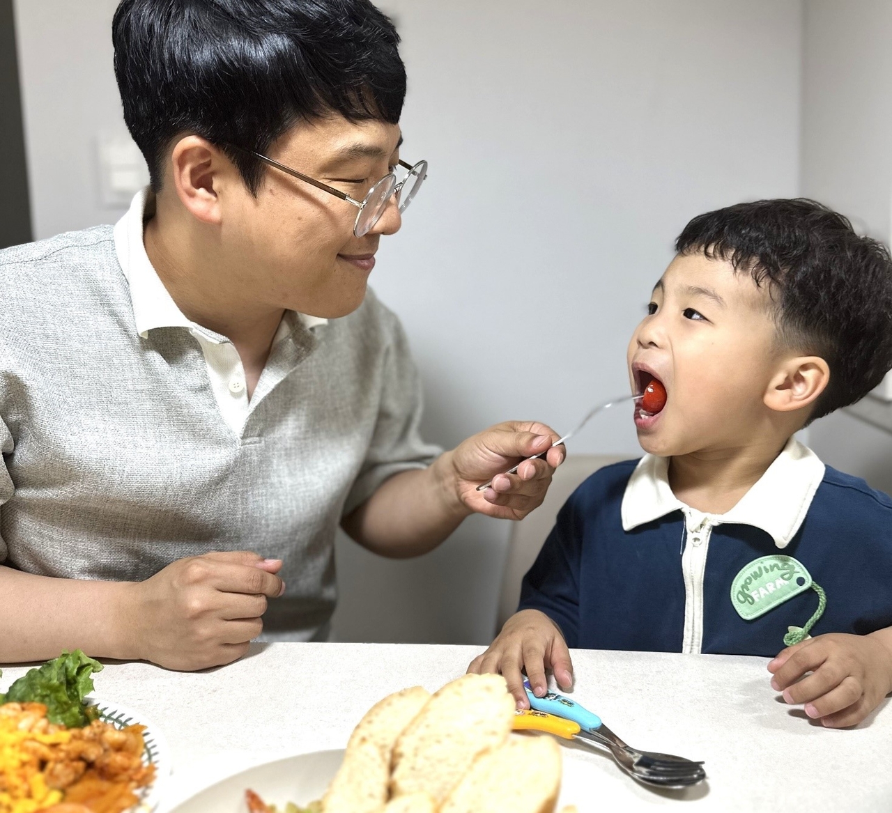 SGC에너지 가족사랑캠페인 중 하나인 ‘홈트레스토랑’ 이미지. 이성택 SGC에너지 차장이 요리한 음식을 자녀가 먹는 모습. [SGC에너지 제공]