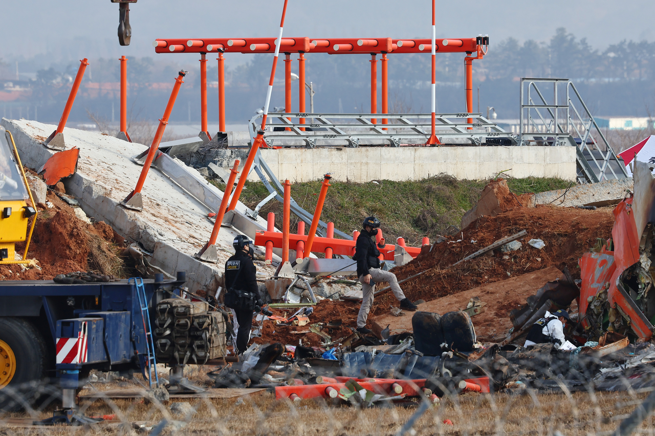 지난달 30일 전남 무안군 무안국제공항 제주항공 여객기 충돌 폭발 사고 현장에서 가상 바카라 과학수사대가 활주로 인근의 방위각 시설(로컬라이저)을 살피고 있다. [연합]