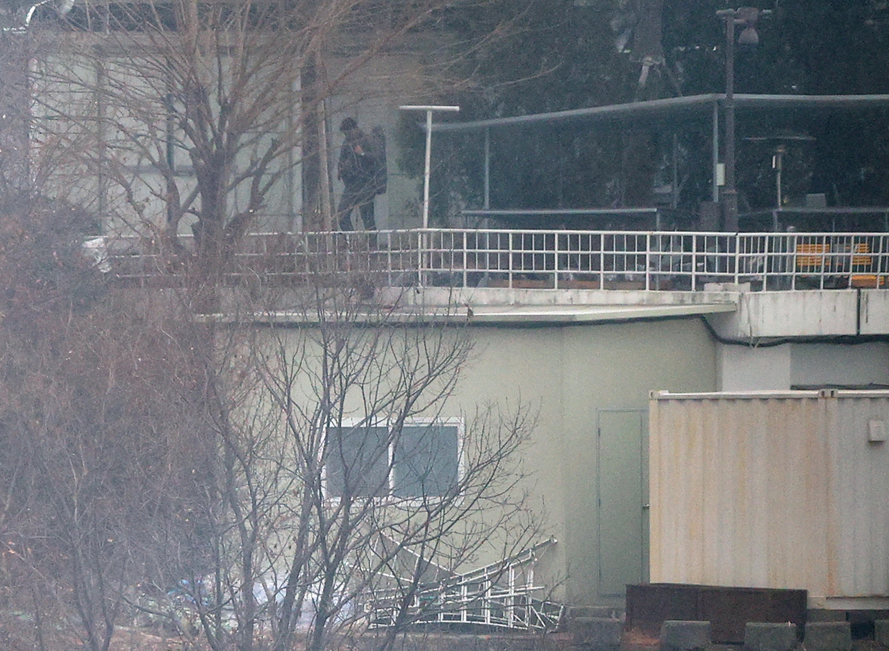 A person believed to be a security guard patrols at impeached President Yoon Suk Yeol's official residence in Seoul on Monday, one week after a court issued a second warrant to detain Yoon in connection to his short-lived imposition of martial law. (Yonhap)