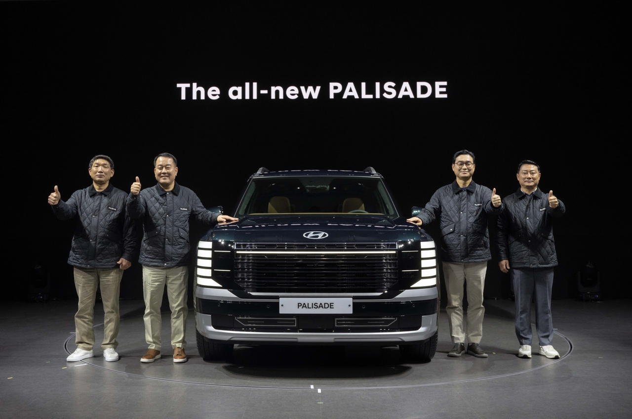 Moon Yong-moon (left), head of the Hyundai Motor branch of the Korea Metal Workers’ Union, and Lee Dong-seock (second from left), president of domestic production at Hyundai Motor, and other company officials pose at Tuesday’s press conference. It is the first time representatives of both management and labor have attended a new car unveiling event held by the company.  (Hyundai Motor Company)