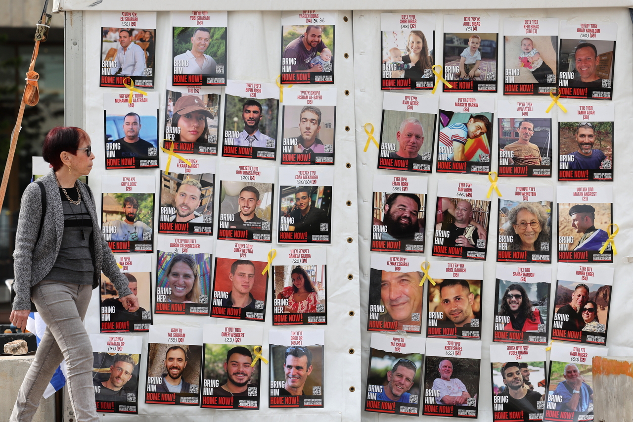 A woman walks past a display of posters calling for the release of Israeli hostages, who were abducted by militants during the Oct. 7, 2023 Hamas attacks, outside the Kirya military headquarters in Tel Aviv, Israel, Friday. EPA-Yonhap