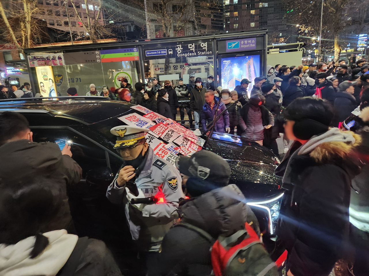 내란 우두머리 혐의로 체포된 윤석열 대통령의 구속 전 피의자심문(영장실질심사)이 종료된 18일 밤 서울 마포구 공덕역 인근에서 윤 대통령 지지자들이 고위공직자범죄수사처(공수처) 추정 차량의 앞을 막고 있다. [연합뉴스]
