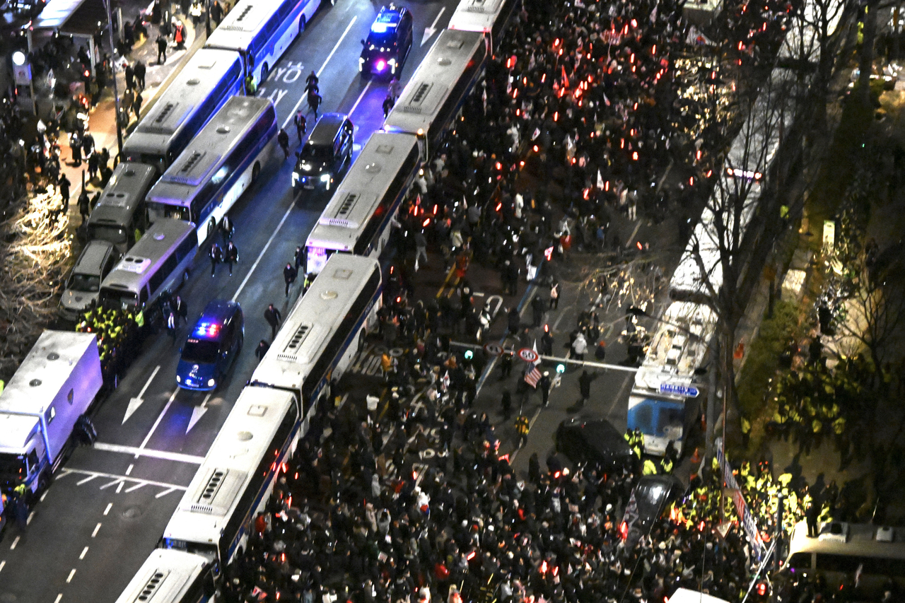 내란 우두머리 혐의로 체포된 윤석열 대통령의 구속 전 피의자심문(영장실질심사)이 종료된 18일 서울 마포구 서부지법 인근에서 윤 대통령이 탄 법무부 호송차량과 경호차량이 서울구치소로 향하고 있다.  [연합뉴스]