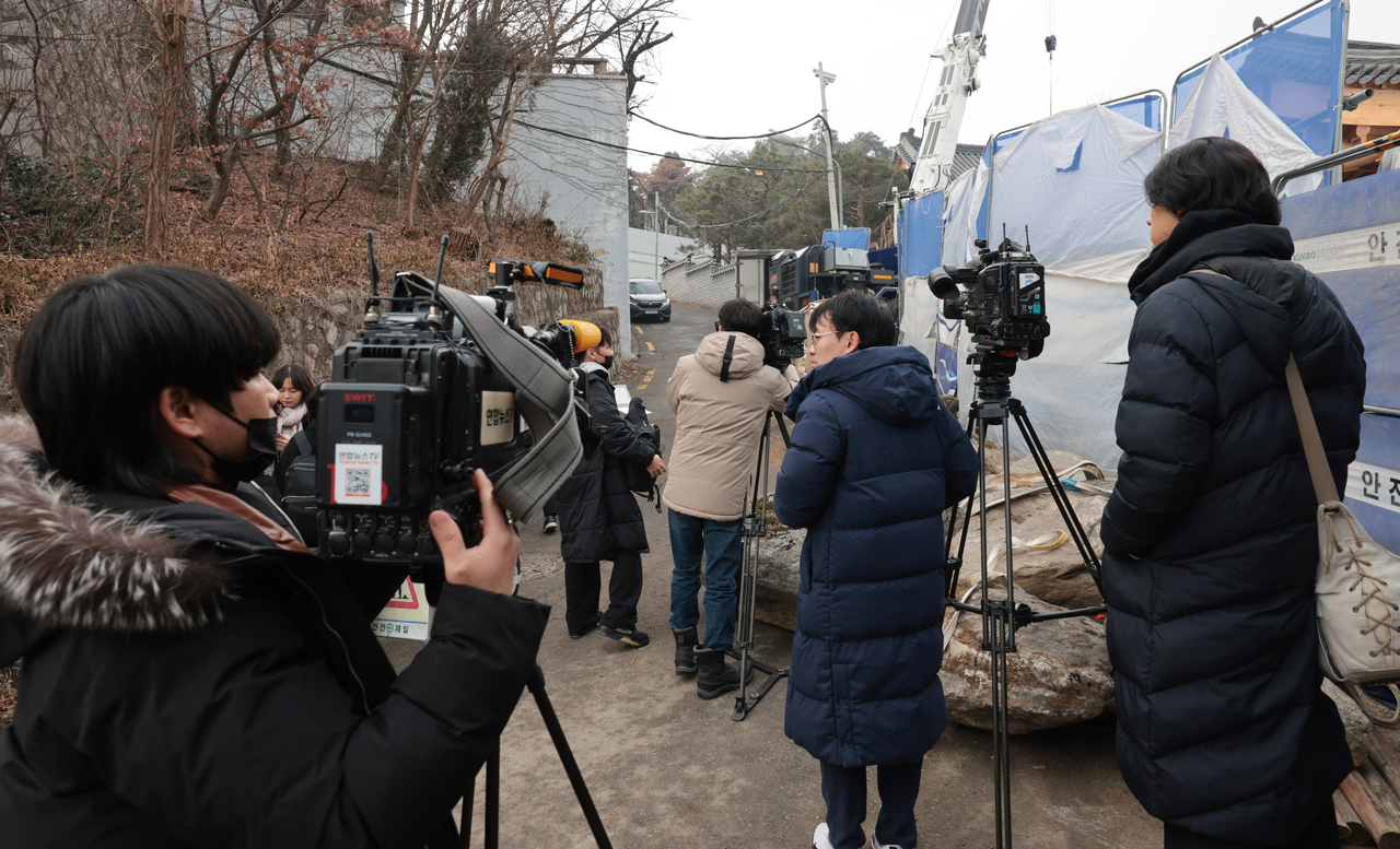경찰 비상계엄 특별수사단이 계엄문건과 폐쇄회로(CC)TV 등을 확보하기 위해 대통령 안전가옥에 대해 압수수색을 진행한 20일 서울 종로구 삼청동 대통령 안가 앞에서 취재진들이 대기하고 있다.[연합]