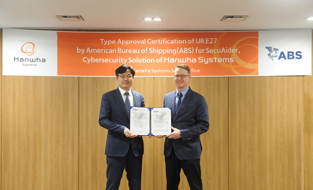 Hanwha Systems Vice President of Naval Division Myeong-Seob Cho (left) and ABS Vice President of Business Development for the Northern Pacific Region, Darren Leskoski take pose in the certification awarding ceremony at Hanwha Systems headquarters in Seoul, Monday. (Hanwha Systems)