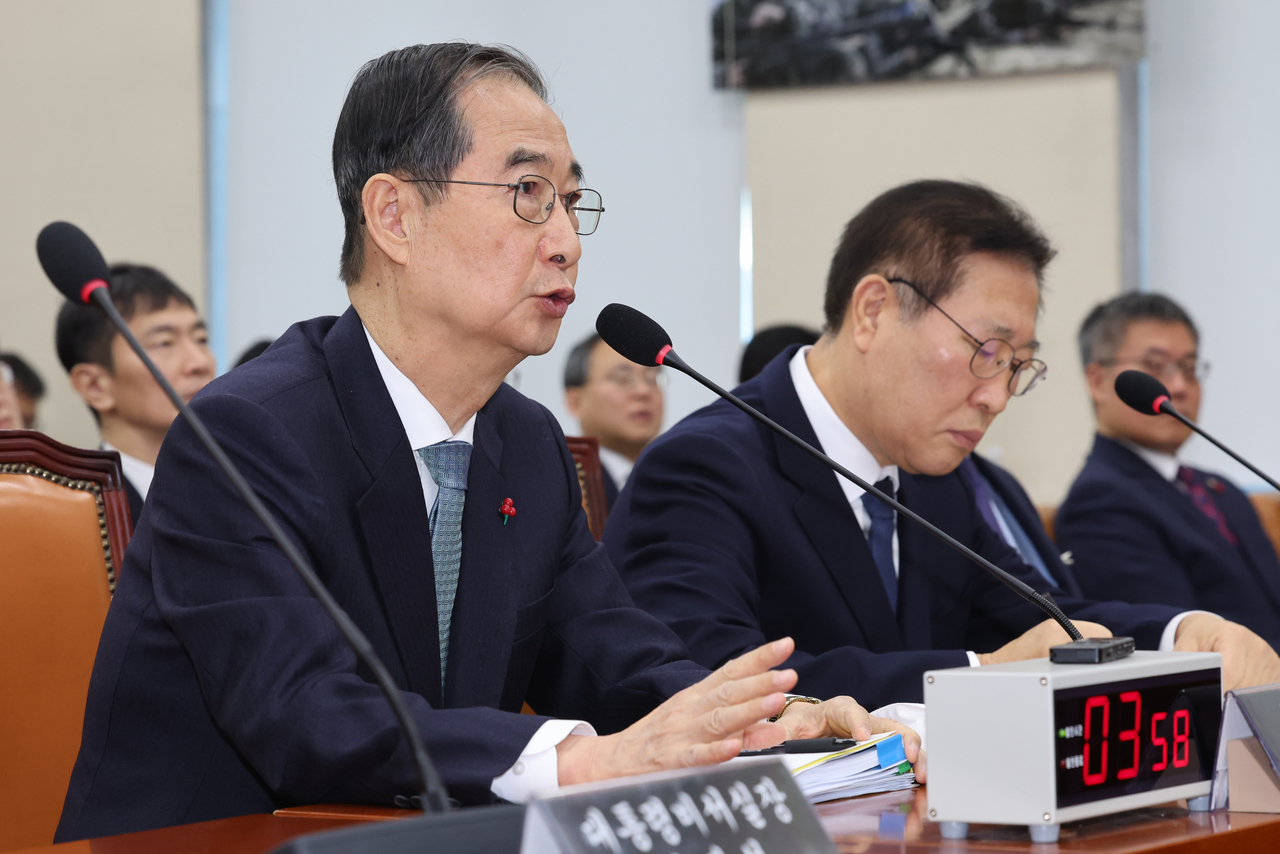 Prime Minister Han Duck-soo (left) speaks to lawmakers at a special parliamentary session into President Yoon Suk Yeol's martial law declaration at the National Assembly in western Seoul on Jan. 15. (Yonhap)
