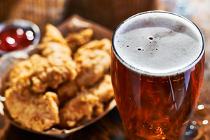 Korean chimaek setup with a plate of crispy fried chicken alongside cold draft beer in a chilled mug