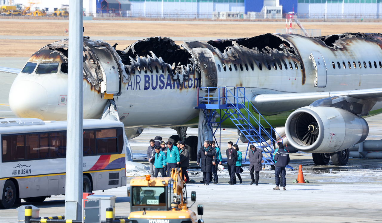 Inspections are being conducted on the Air Busan plane that caught fire late Tuesday night before takeoff at Gimhae International Airport in Busan, Wednesday. (Yonhap)