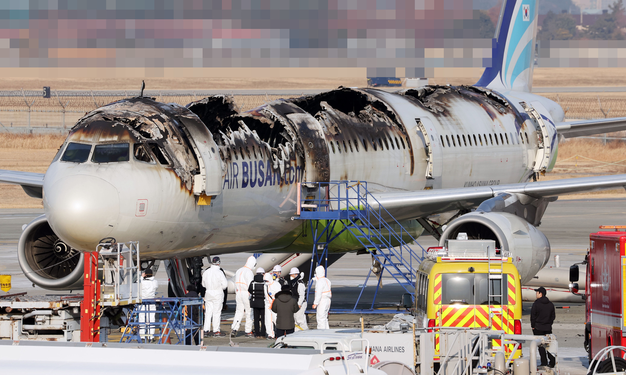 Officials from South Korea and France assess safety risks at the burned Air Busan aircraft at Gimhae International Airport on Friday ahead of the full-scale joint investigation into the incident scheduled for next Monday. (Newsis)
