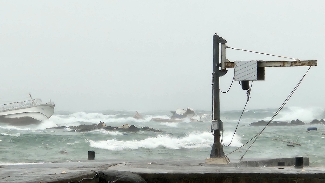 This photo, provided by fire services on Jeju Island on Saturday, shows the scene of two fishing boats capsizing in waters off the island. (Yonhap)