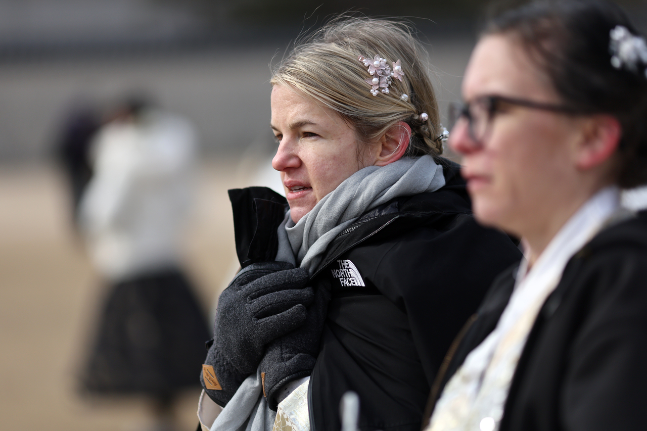 During the Lunar New Year holiday, tourists bundle up near Gyeongbokgung in Seoul on Jan. 30. (Yonhap)
