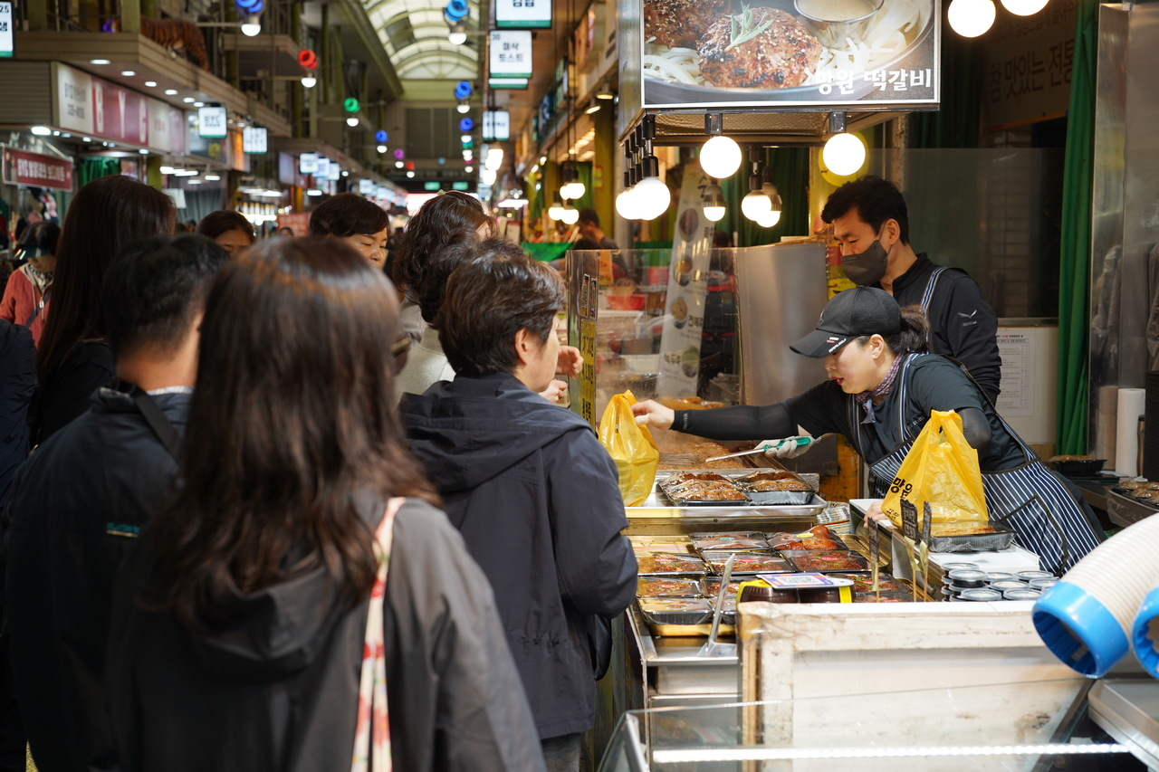 Visitors wait in line to buy tteokgalbi, or short rib patties, at Mangwon Market in Mapo-gu, western Seoul. (Lee Si-jin/The Korea Herald)