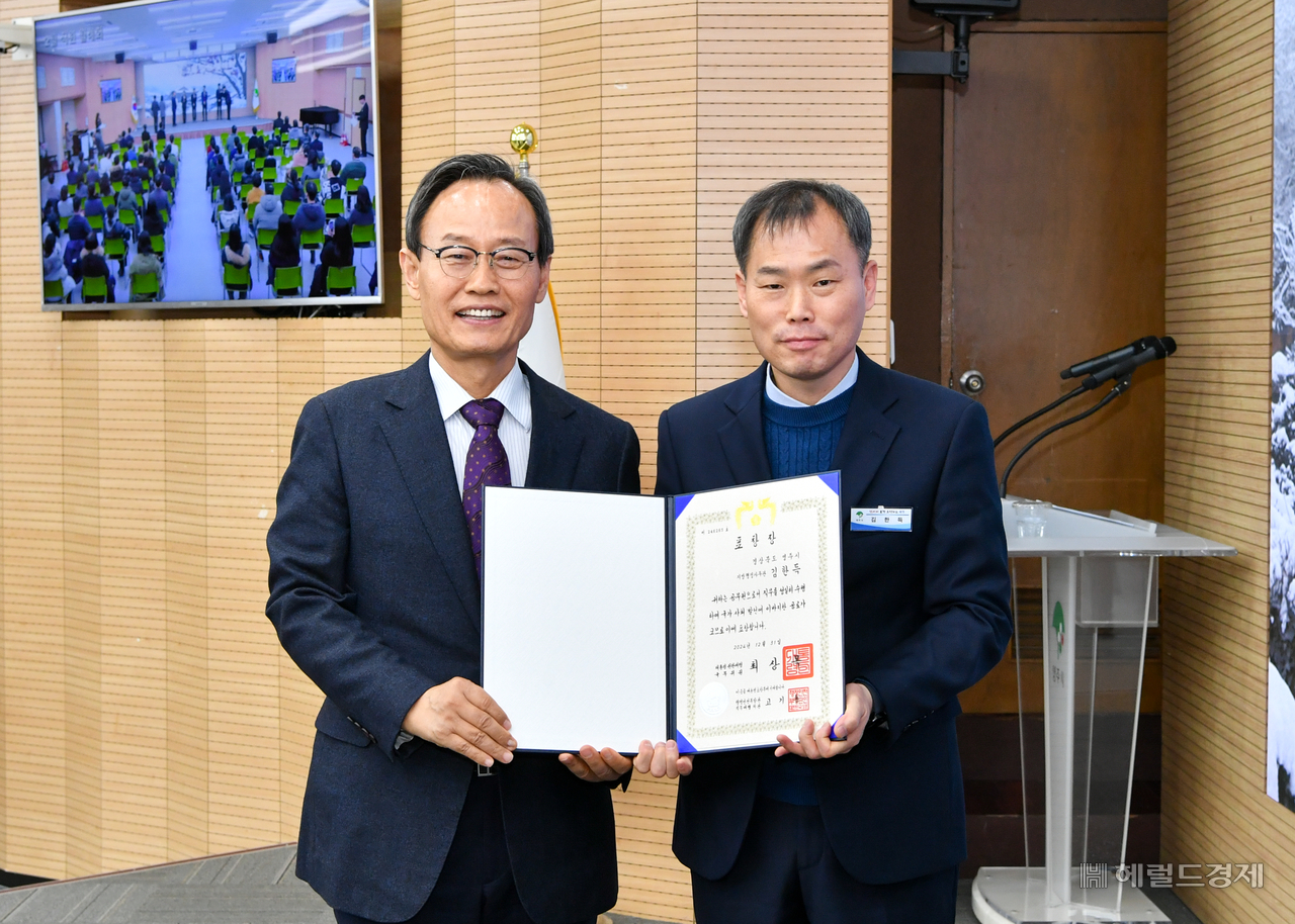 김한득(오른쪽)  영주시 홍보전산실장이 박남서 시장으로부터  대통령 표창을 전수받고 있댜(영주시 제공)