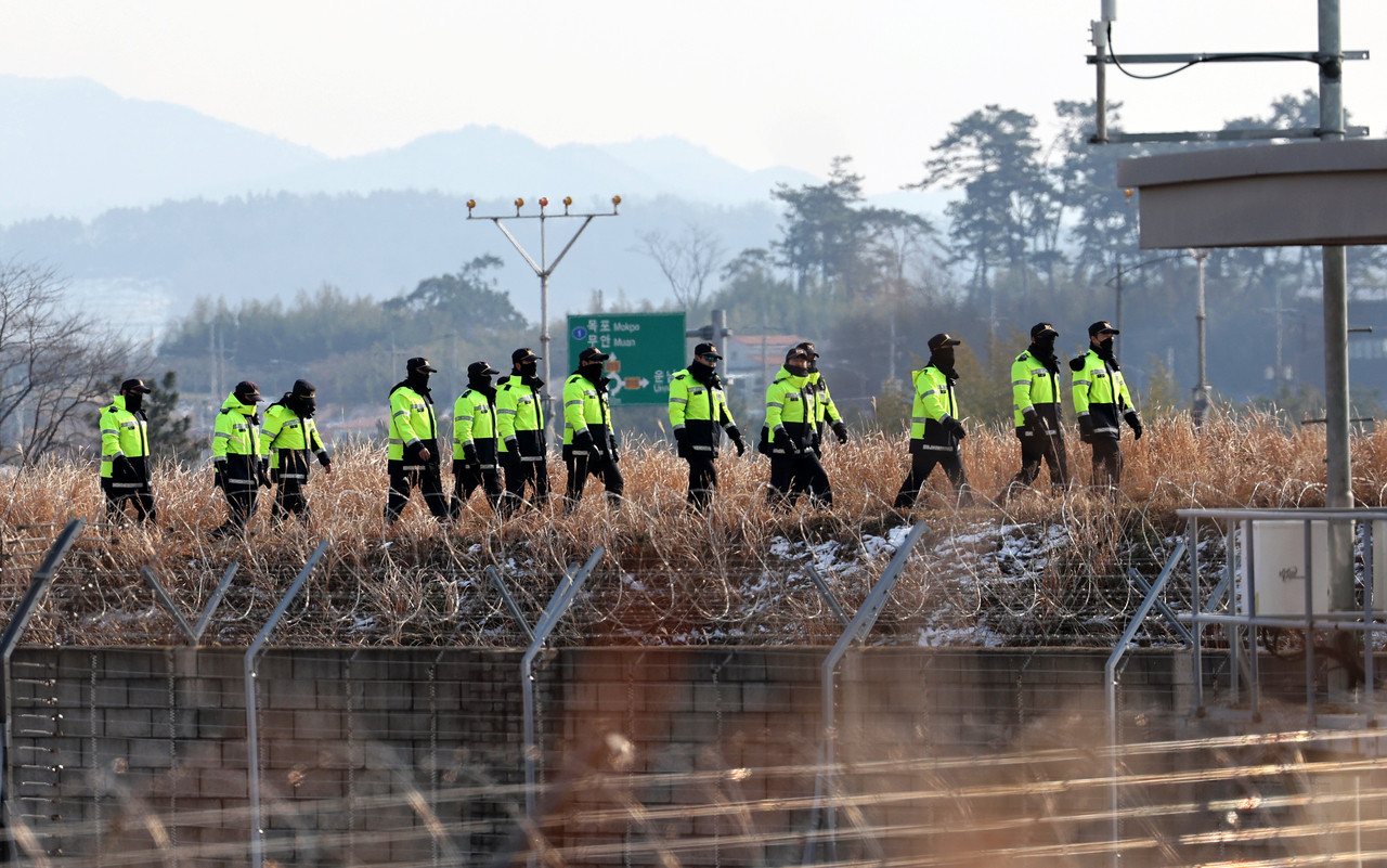 제주항공 참사 15일째인 지난달 12일 오후 전남 무안국제공항에서 경찰들이 사고 현장을 둘러보고 있다. [연합]