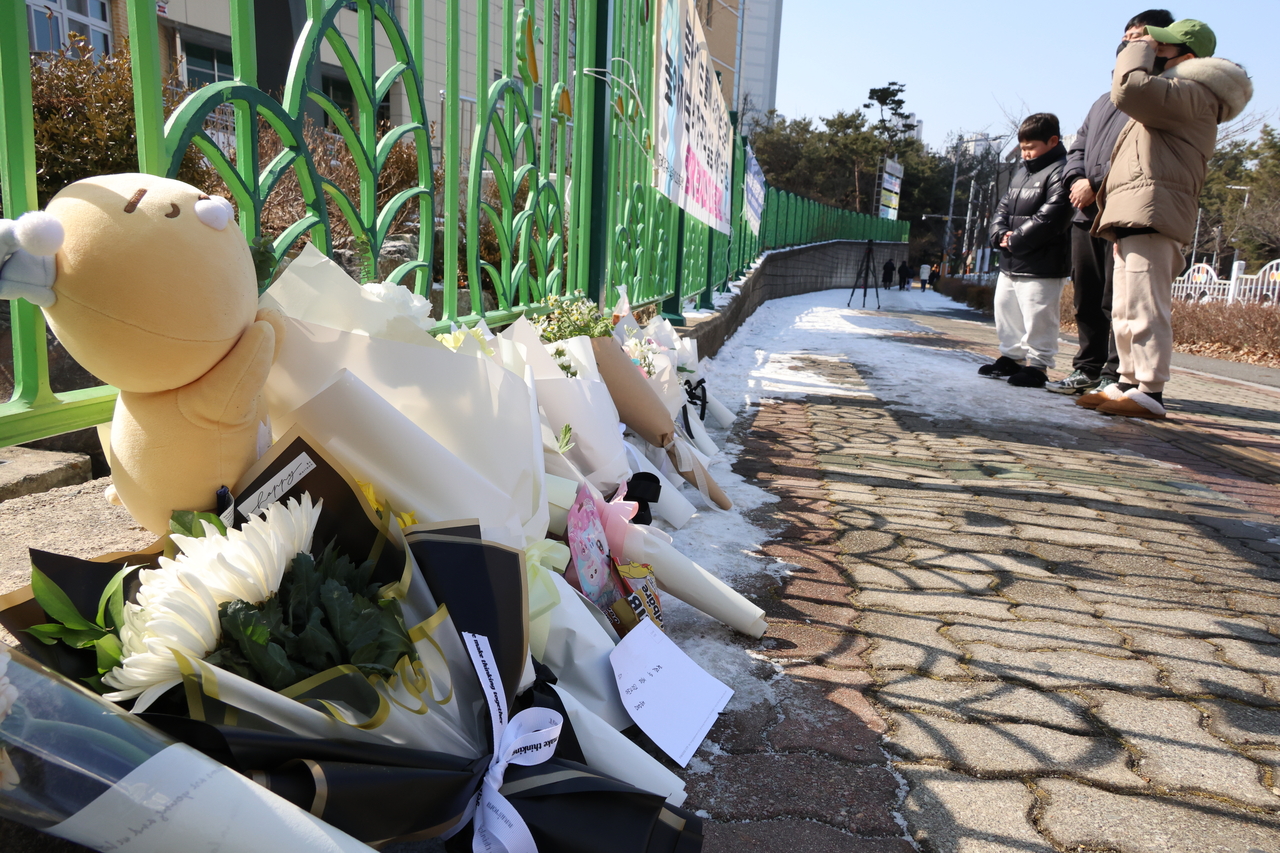 11일 오전, 초등생 1학년 여아가 살해당한 대전 서구 한 초등학교에서 학부모가 어린 자녀와 함께 사망한 김하늘 양을 위해 추모를 하고 있다. [연합]