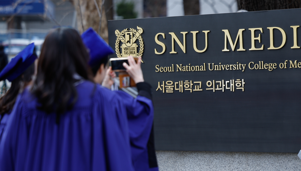Students take photos to mark their graduation from Seoul National University’s College of Medicine in February 2024. (Newsis)