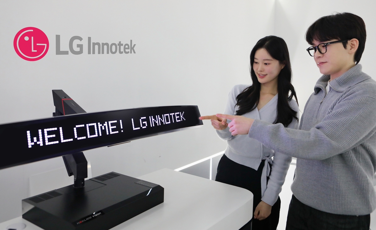 LG이노텍 직원들이 차량 정차 시 원하는 메시지를 띄워 보여줄 수 있는 차량조명 모듈 신제품 ‘넥슬라이드 비전’을 소개하고 있다. [LG이노텍 제공]