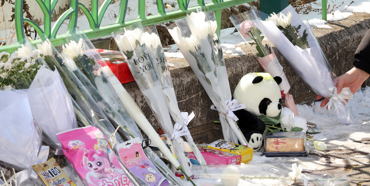 Chrysanthemums, snacks and post-it notes are laid in front of an elementary school in Daejeon on Tuesday, a day after an eight-year-old student was fatally stabbed by a teacher. (Newsis)