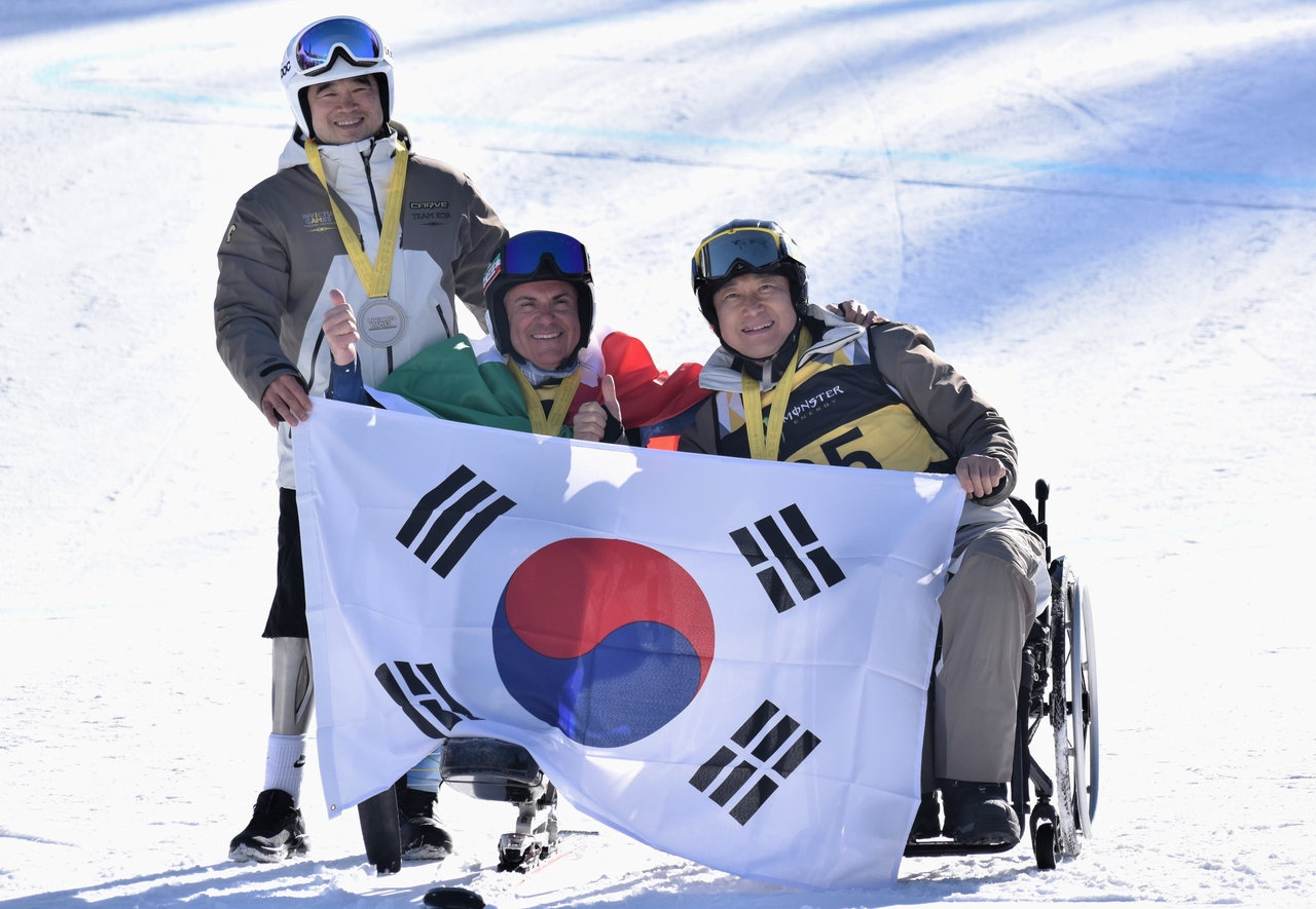 12일(현지시간) 휘슬러 스키경기장에서 펼쳐진 2025 캐나다 인빅터스 게임 좌식 스키 시상식에서 은메달을 획득한 이환경(왼쪽)과 동메달을 획득한 김영민(오른쪽) 선수가 태극기를 펼쳐들고 기념 촬영을 하고 있다.[보훈부 공동취재단(휘슬러)]