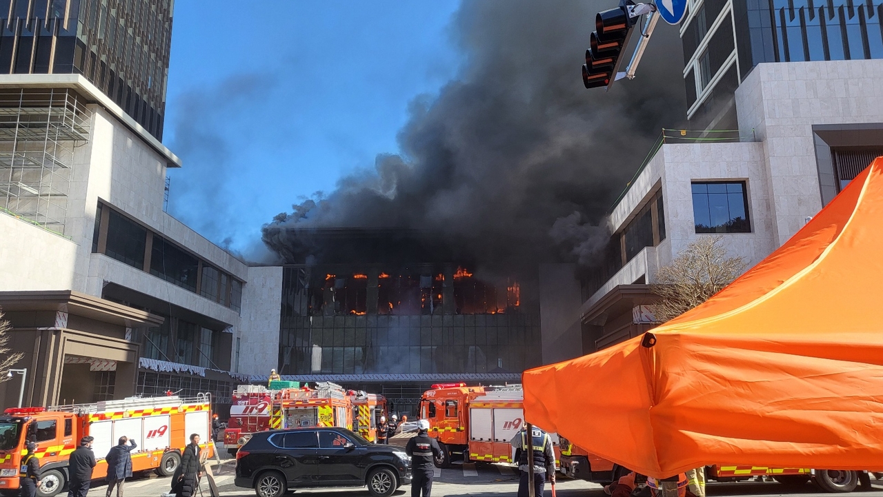 Flames and heavy smoke billow from the Banyan Tree hotel construction site in Busan on Friday, as emergency crews work to contain the blaze. (Yonhap)