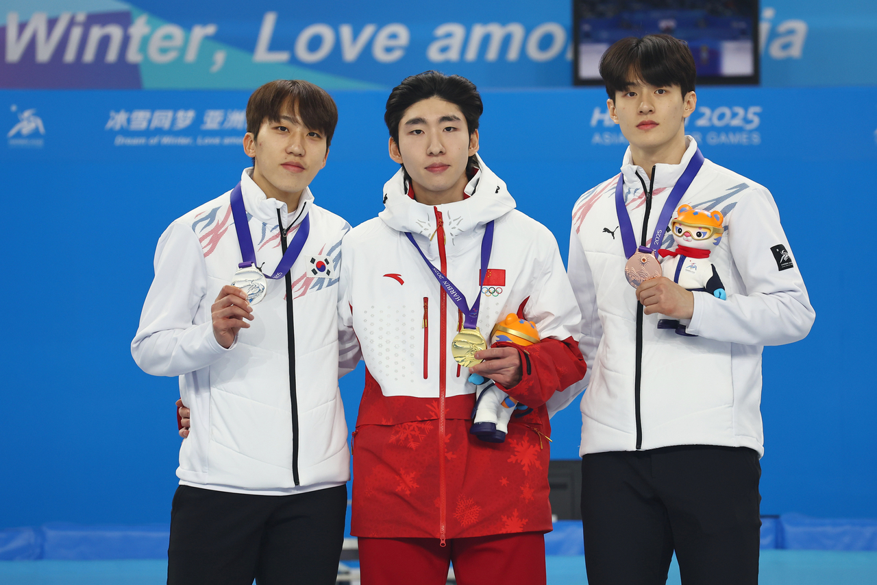 지난 8일 하얼빈 동계아시안게임 쇼트트랙 남자 500m 시상식에서 금메달을 따낸 중국 린샤오쥔(가운데)가 은메달 박지원(왼쪽)이 서로 허리를 감싸안으며 기념촬영을 하고 있다. [연합]