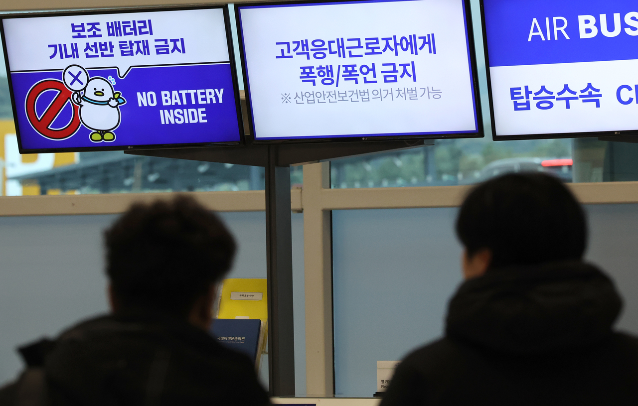 Signs saying that portable power banks are not to be stored in overhead bins are displayed at Jeju International Airport on Feb. 7. (Yonhap)