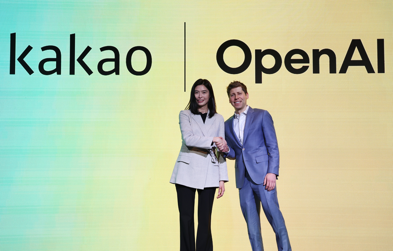 Kakao CEO Chung Shin-a (left) shakes hands with OpenAI CEO Sam Altman during a press conference at a Seoul hotel on Feb. 4. (Yonhap)