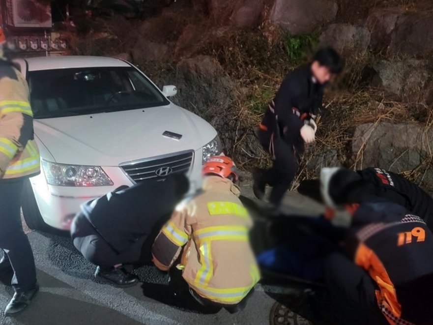 지난 18일 밤 제주시 이도2동에서 50대 남성이 차량에 깔려 구조되고 있다. [제주도소방안전본부 제공]