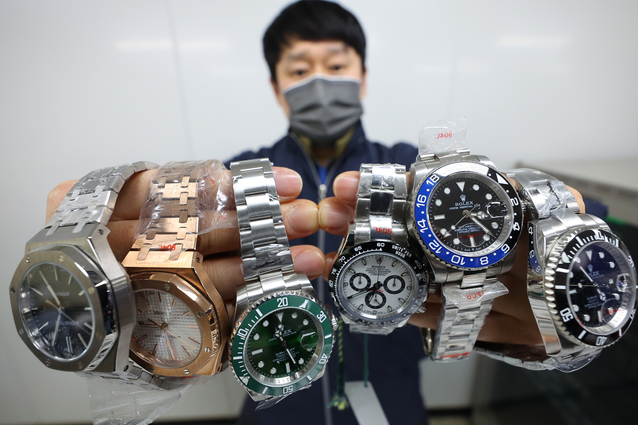 A police offcer shows watches confiscated from a store in Myeong-dong, Seoul, where two individuals were caught selling counterfeit goods to foreigners.  (Yonhap)