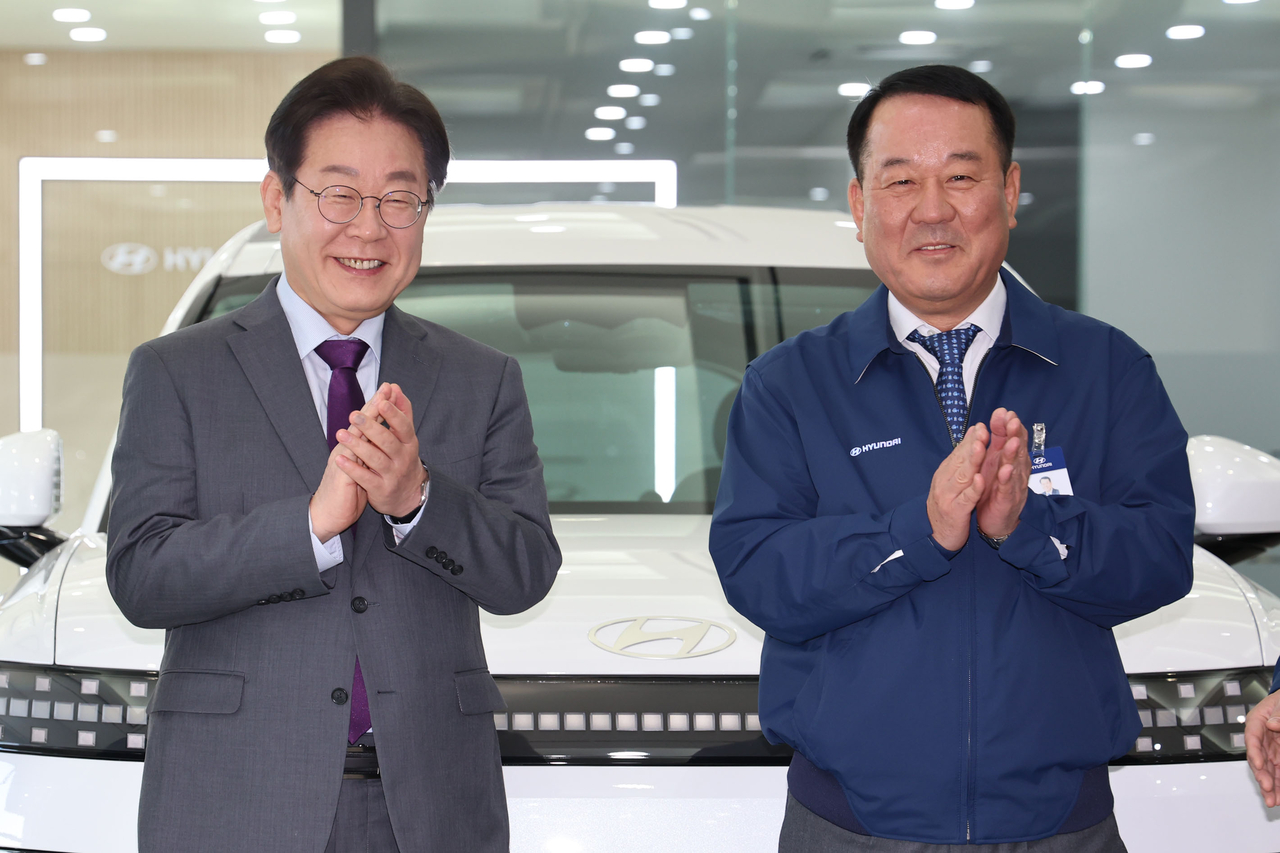 Main opposition Democratic Party of Korea Chair Rep. Lee Jae-myung (left) and Hyundai Motor President and Chief Executive Officer Lee Dong-seock pose in front of the Ioniq 9, an all-electric SUV, during a visit to the Hyundai Motor manufacturing plant in Asan, South Chungcheong Province, Thursday. (Newsis)