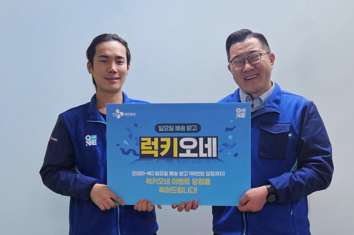 ‘럭키 오네’ 이벤트 첫 당첨자인 CJ대한통운 택배기사 최우석(왼쪽) 씨가 이종복 CJ대한통운 군포지사장과 기념사진 촬영을 하고 있다.  [CJ대한통운 제공]