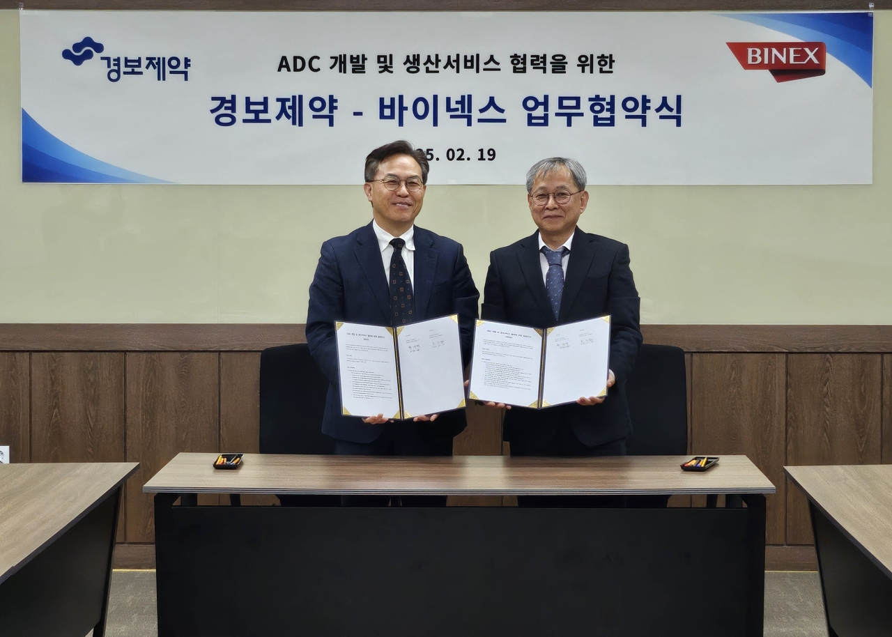19일 바이넥스 송도공장에서 황재택 경보제약 전무(왼쪽)와 조진섭 바이넥스 전무가 업무협약을 맺고 기념촬영을 하고 있다. [경보제약 제공]