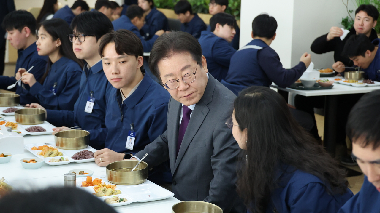 Main opposition Democratic Party of Korea Chair Rep. Lee Jae-myung talks with employees over lunch during a visit to the Hyundai Motor manufacturing plant in Asan, South Chungcheong Province, on Thursday. (Yonhap)