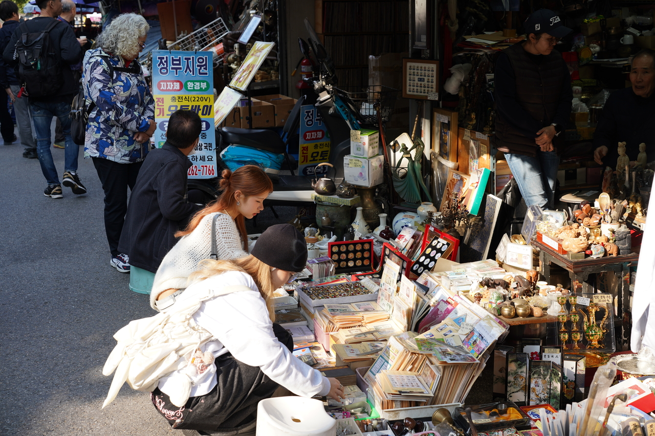 People examine items on display at Hwanghakdong Flea Market on Oct. 24. (Lee Si-jin/The Korea Herald)