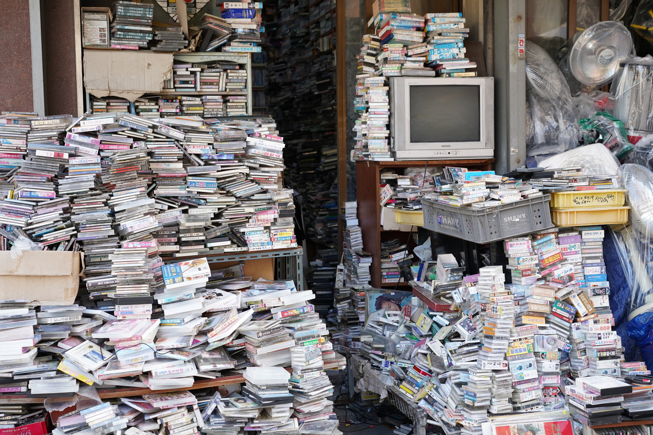 Piles of cassette tapes and CDs sit on tables at a shop in Hwanghakdong Flea Market in Jongno-gu, central Seoul. (Lee Si-jin/The Korea Herald)