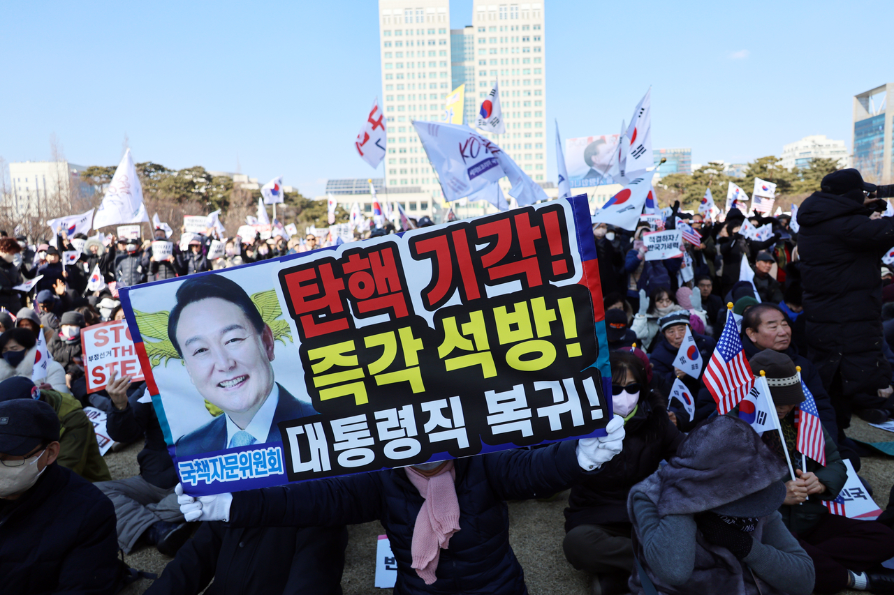 22일 대전 서구 대전시청 앞 보라매공원에서 세이브코리아 국가비상기도회가 열린 가운데 집회 참석자들이 태극기와 피켓을 흔들고 있다. <연합뉴스