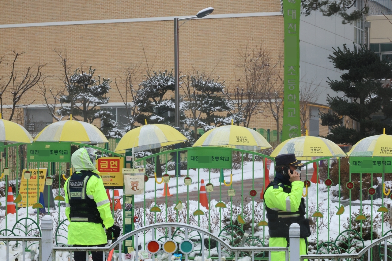 Police patrol in front of a school in Daejeon where a teacher fatally stabbed a first grader on Monday. (Yonhap)