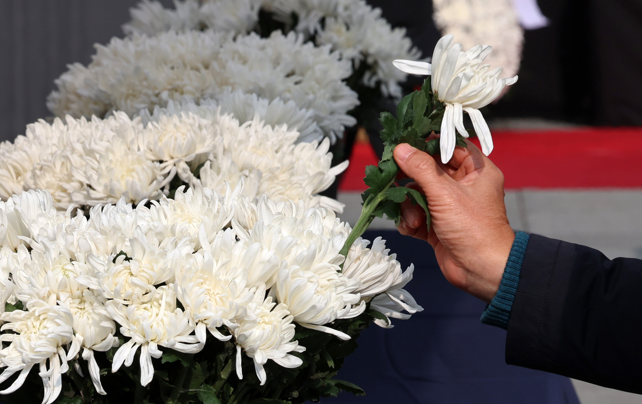 A person lays flowers at a memorial in Seoul. (Newsis)