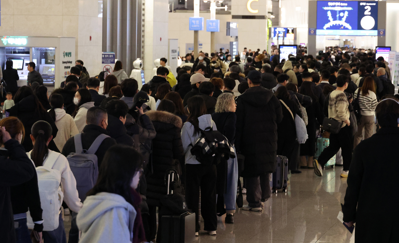 Passengers queue at Incheon Airport, west of Seoul, Jan. 26. (Yonhap)