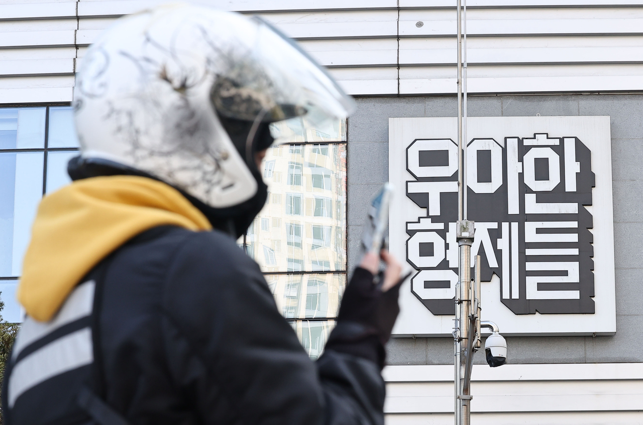 서울 송파구 우아한형제들 본사 앞에서 한 배달 기사가 사진 촬영을 하는 모습. [연합]