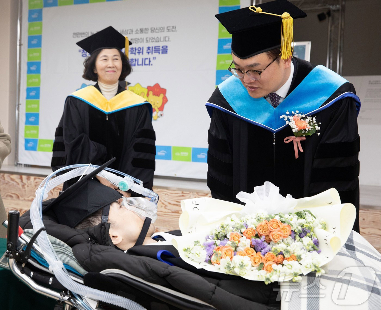 Gwangju University President Kim Dong-jin presents a master’s degree to Jang Ik-seon, a graduate with muscular dystrophy, during a special graduation ceremony at the campus last Friday. (Gwangju University)