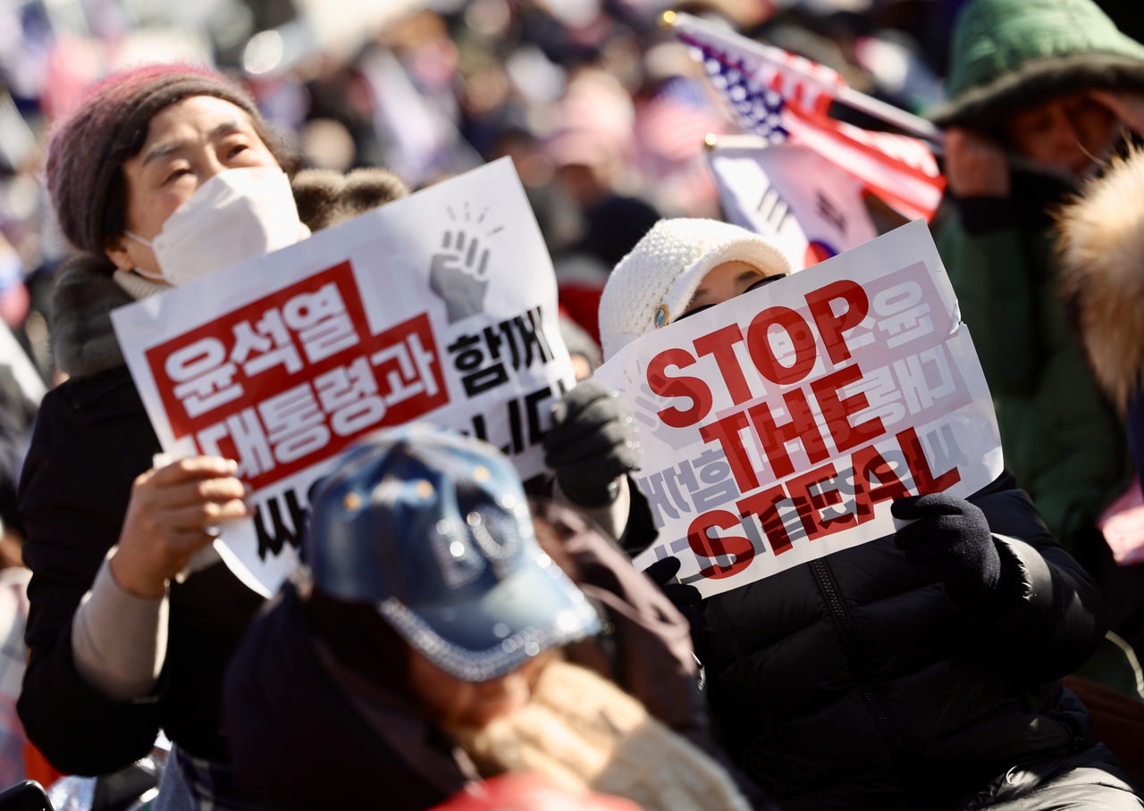 Supporters of impeached South Korean President Yoon Suk Yeol rally near his official residence in Seoul on Jan. 10, holding signs denouncing election fraud amid ongoing political turmoil following his December 2024 martial law declaration. (Newsis)