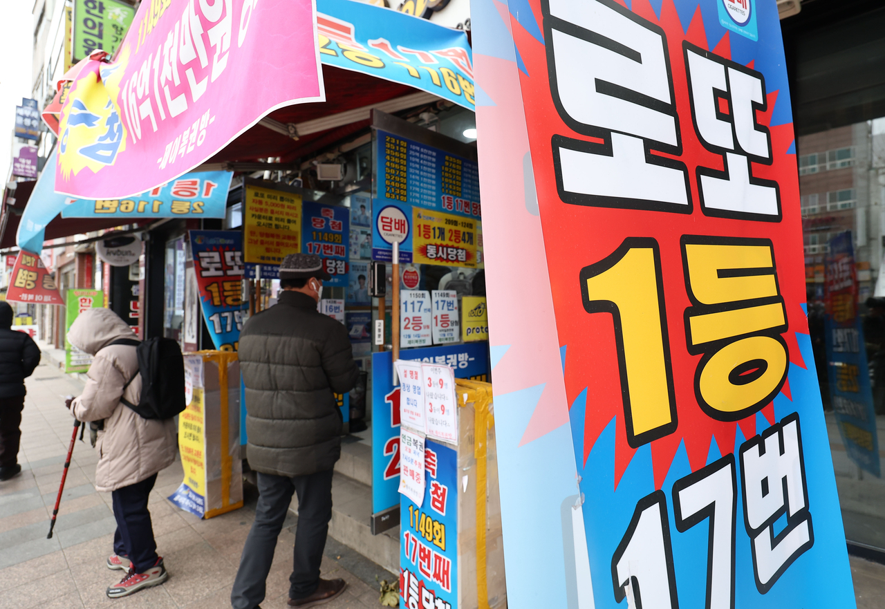 ‘로또명당’으로 알려진 서울 종로구의 한 복권판매점 앞에 시민들이 복권 구입을 위해 줄을 서 있다. [연합]